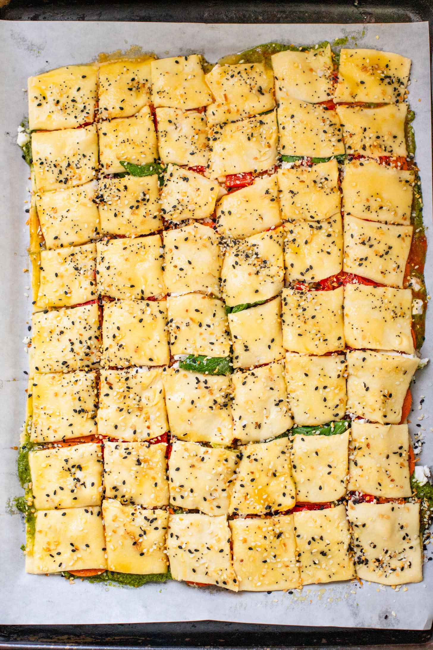 These Puff Pastry Pesto Pizza Bites are the best vegan appetizer. Layers of pizza toppings on puff pastry that is baked until golden | ThisSavoryVegan.com