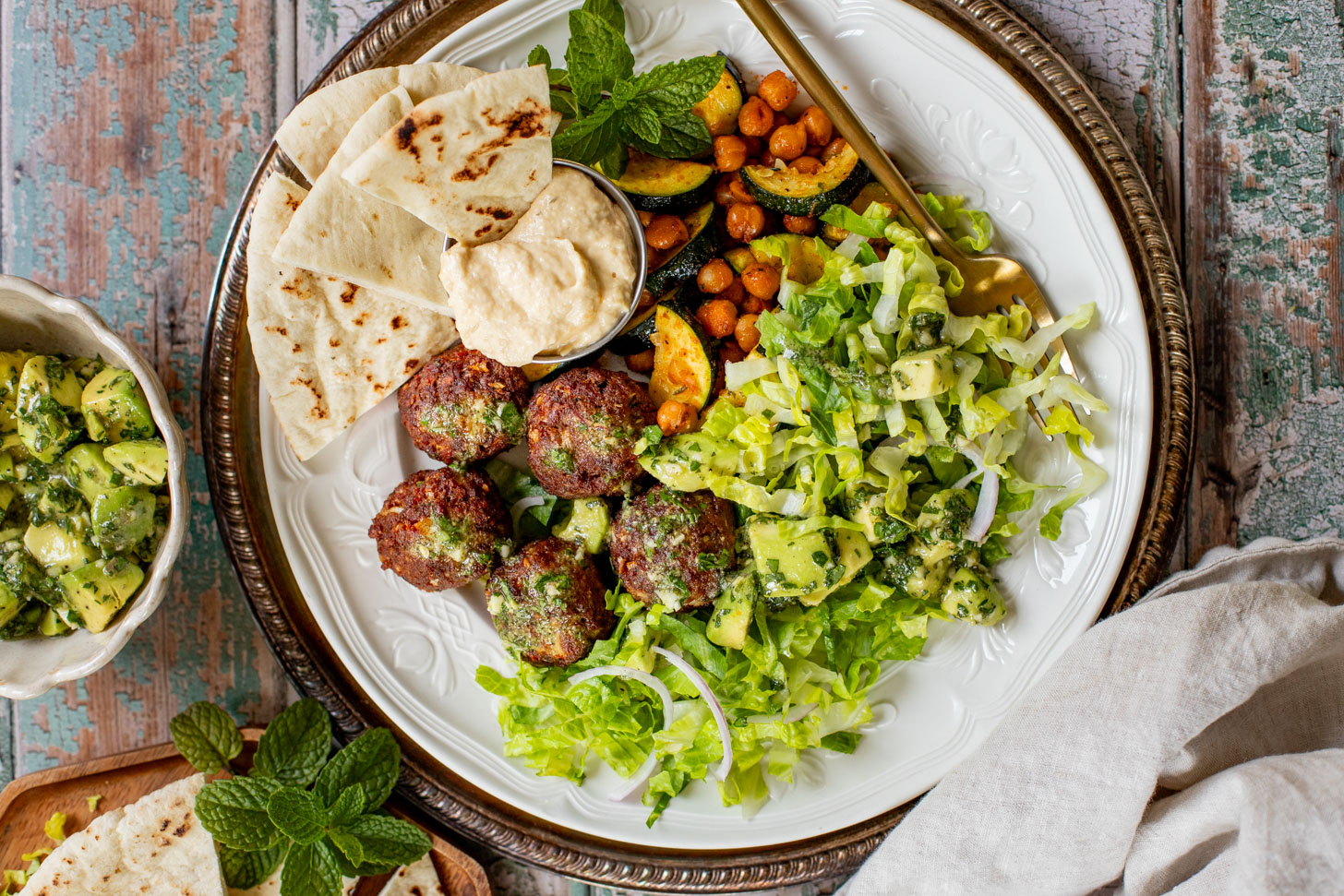 These Sheet Pan Vegan Harissa Meatballs are a high protein vegan meal idea. Served with roasted zucchini, chickpeas and avocado dressing | ThisSavoryVegan.com