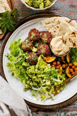 These Sheet Pan Vegan Harissa Meatballs are a high protein vegan meal idea. Served with roasted zucchini, chickpeas and avocado dressing | ThisSavoryVegan.com