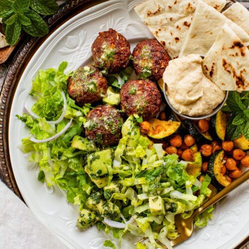 These Sheet Pan Vegan Harissa Meatballs are a high protein vegan meal idea. Served with roasted zucchini, chickpeas and avocado dressing | ThisSavoryVegan.com