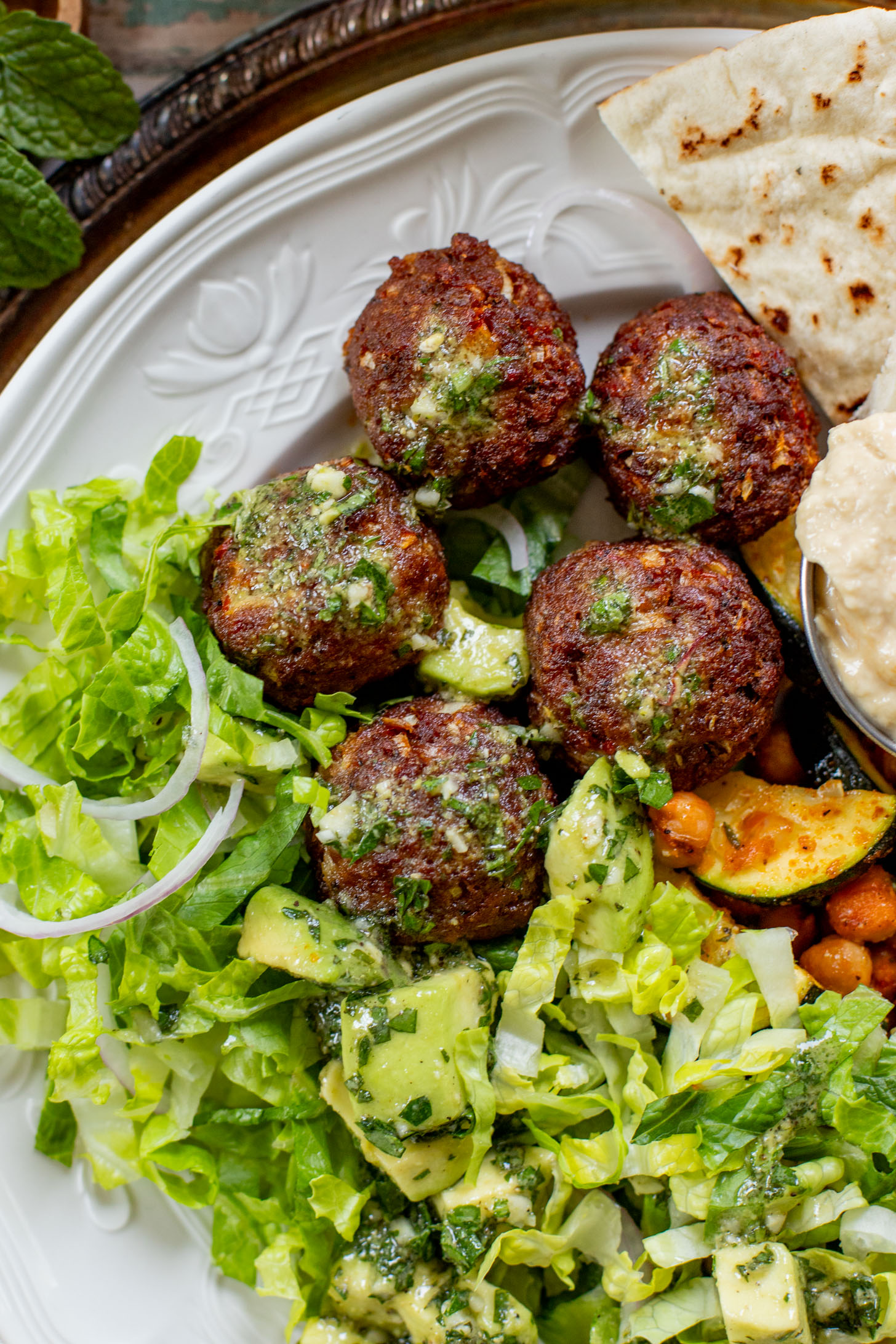 These Sheet Pan Vegan Harissa Meatballs are a high protein vegan meal idea. Served with roasted zucchini, chickpeas and avocado dressing | ThisSavoryVegan.com