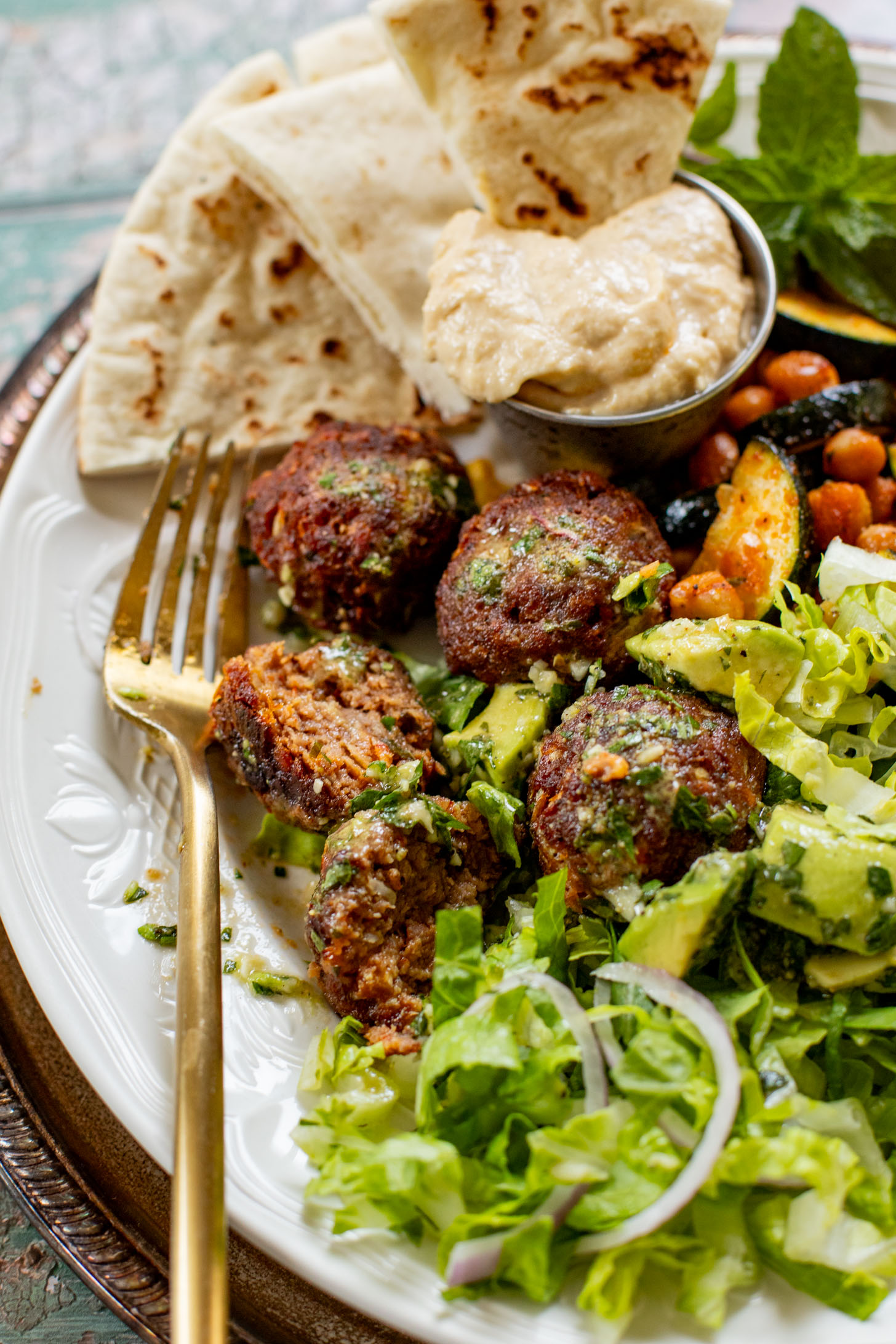 These Sheet Pan Vegan Harissa Meatballs are a high protein vegan meal idea. Served with roasted zucchini, chickpeas and avocado dressing | ThisSavoryVegan.com