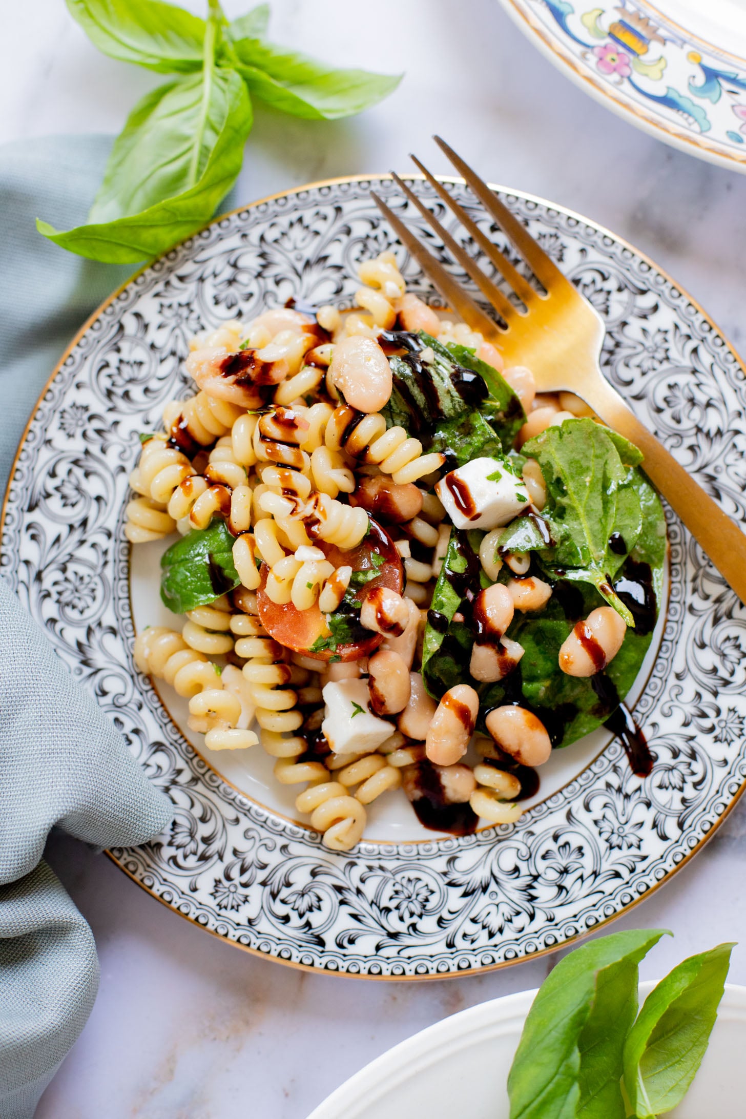 This White Bean Balsamic Pasta Salad is a summer must make! Made with vegan feta, cherry tomatoes, herbs, white beans & balsamic dressing | ThisSavoryVegan.com
