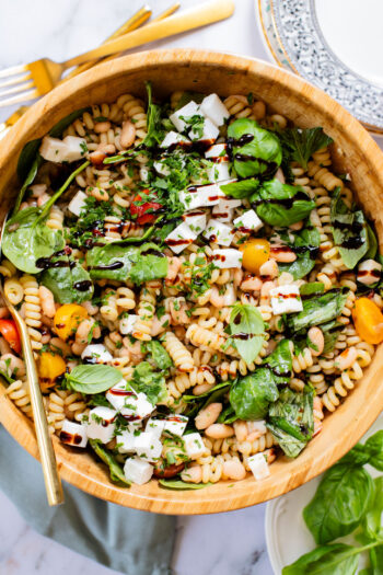 This White Bean Balsamic Pasta Salad is a summer must make! Made with vegan feta, cherry tomatoes, herbs, white beans & balsamic dressing | ThisSavoryVegan.com