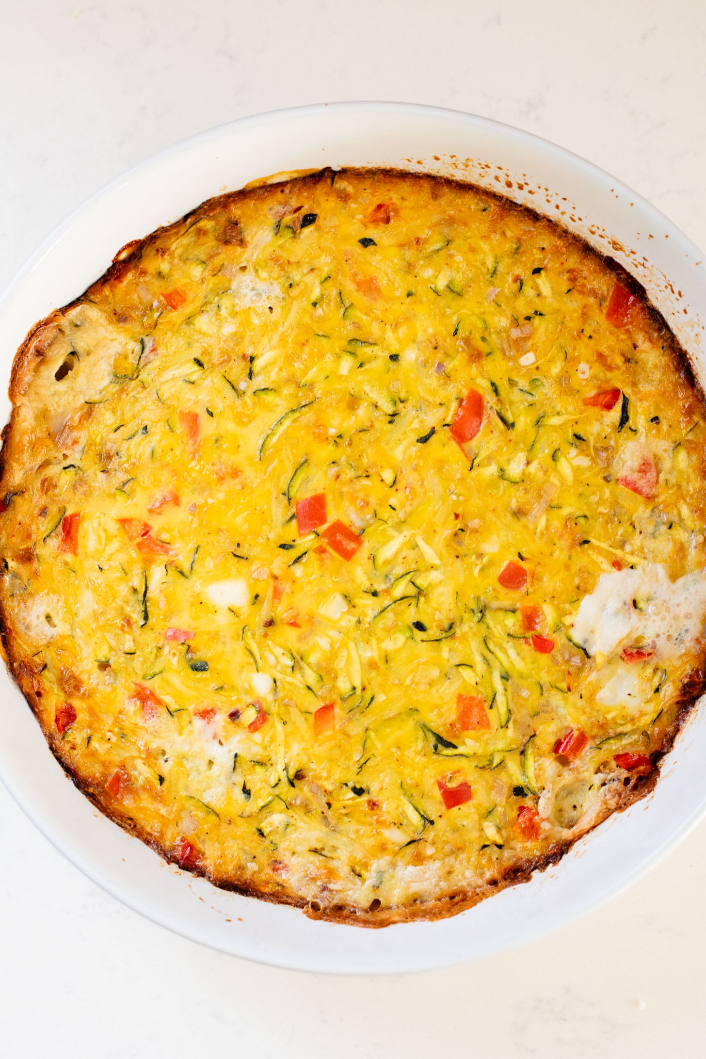 This Zucchini & Potato Vegan Egg Bake is the perfect summer brunch idea! Shredded zucchini & potatoes are baked with Just Egg | ThisSavoryVegan.com