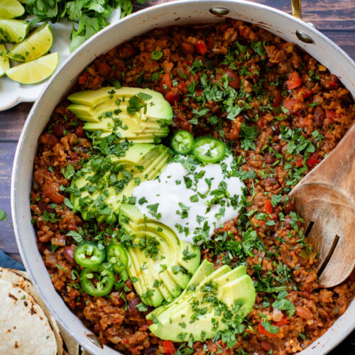 If you are in need of a low carb vegan dinner idea then you need to try this Cauliflower Rice Taco Skillet! Filled with veggies, beans & TONS of flavor | ThisSavoryVegan.com