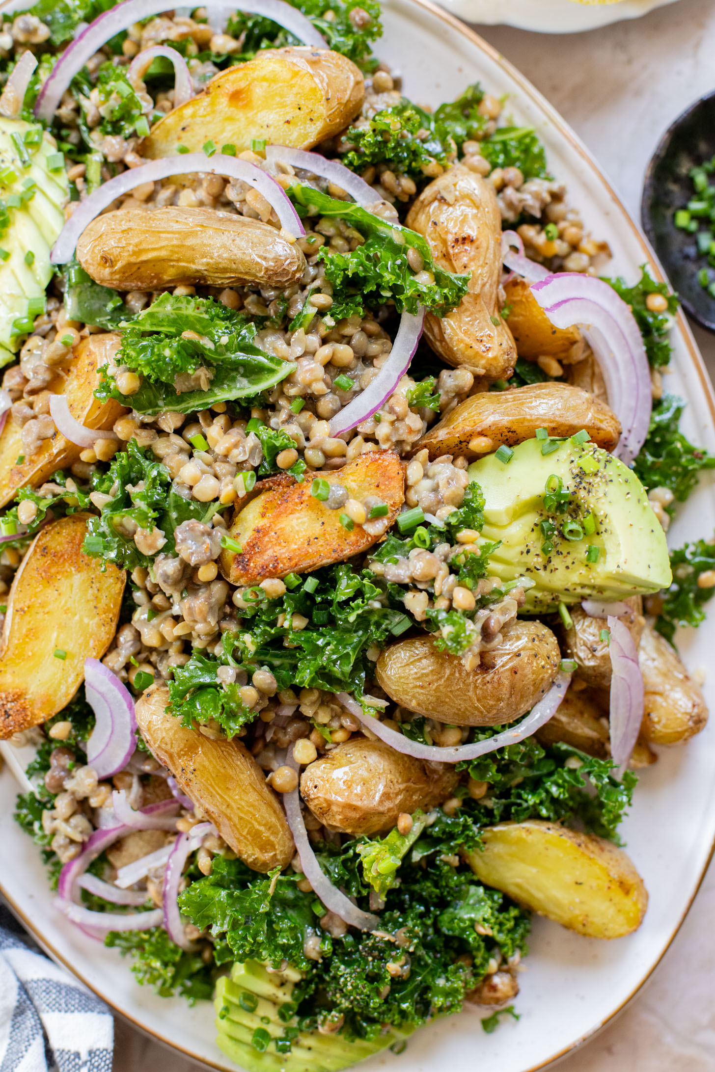 This Fingerling Potato & Lentil Salad is layered with crunchy kale, roasted potatoes, chilled lentils, avocado & a lemon chive dressing | ThisSavoryVegan.com