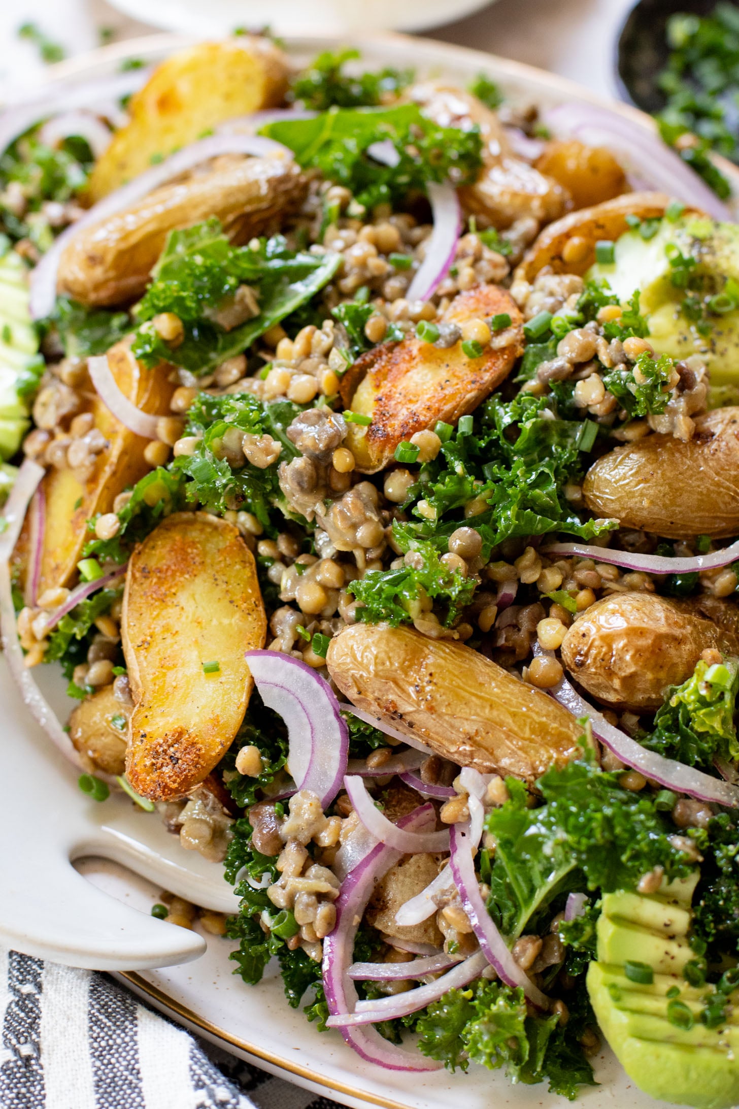 This Fingerling Potato & Lentil Salad is layered with crunchy kale, roasted potatoes, chilled lentils, avocado & a lemon chive dressing | ThisSavoryVegan.com