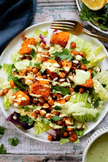 This Roasted Sweet Potato Salad is the perfect quick lunch or dinner! Served with quinoa, greens, avocado & tahini dressing | ThisSavoryVegan.com