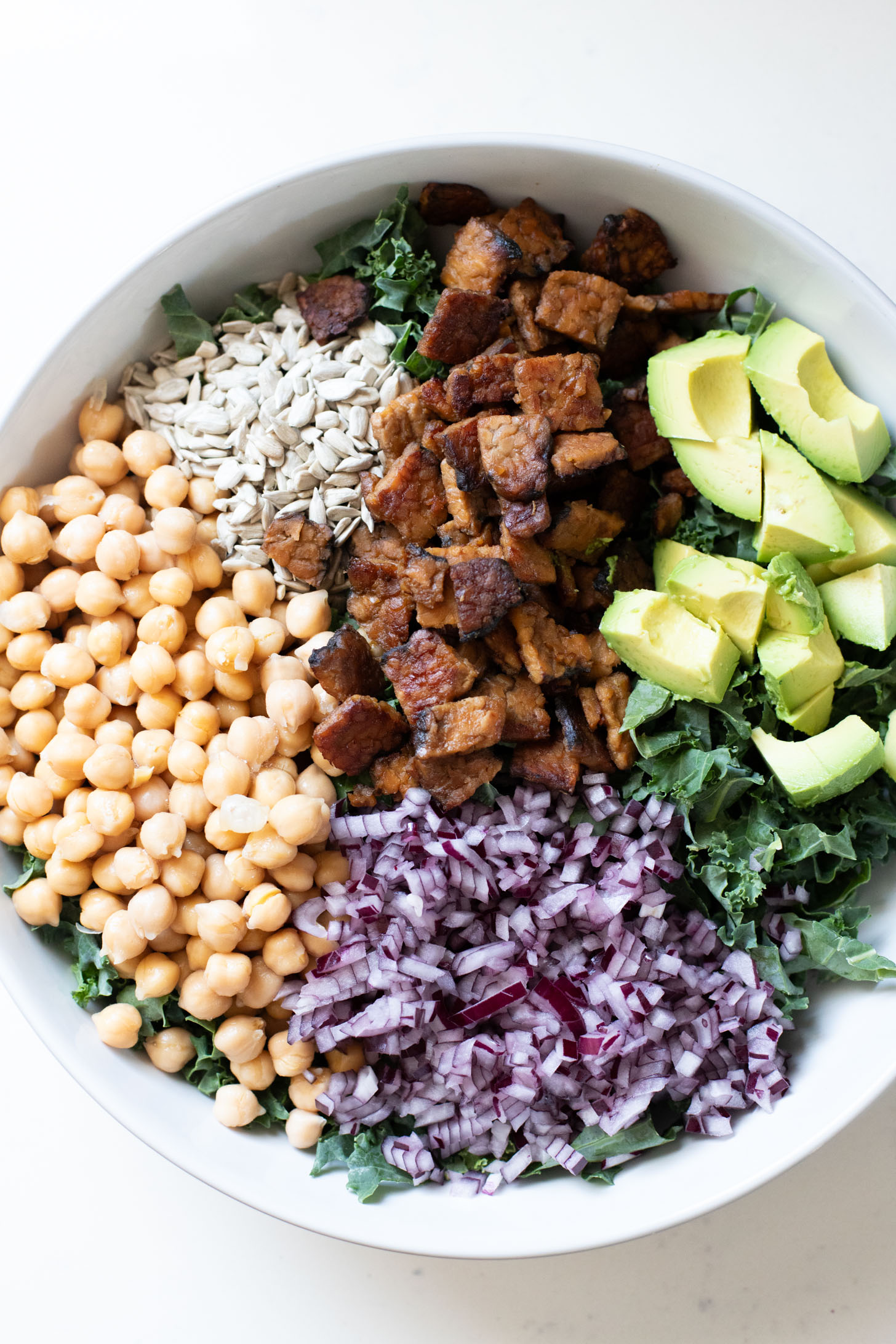 Healthy & delicious, this Tempeh Bacon Kale Salad is a vegan dream! Made with crispy tempeh bacon, chickpeas, avocado & lemon tahini dressing | ThisSavoryVegan.com