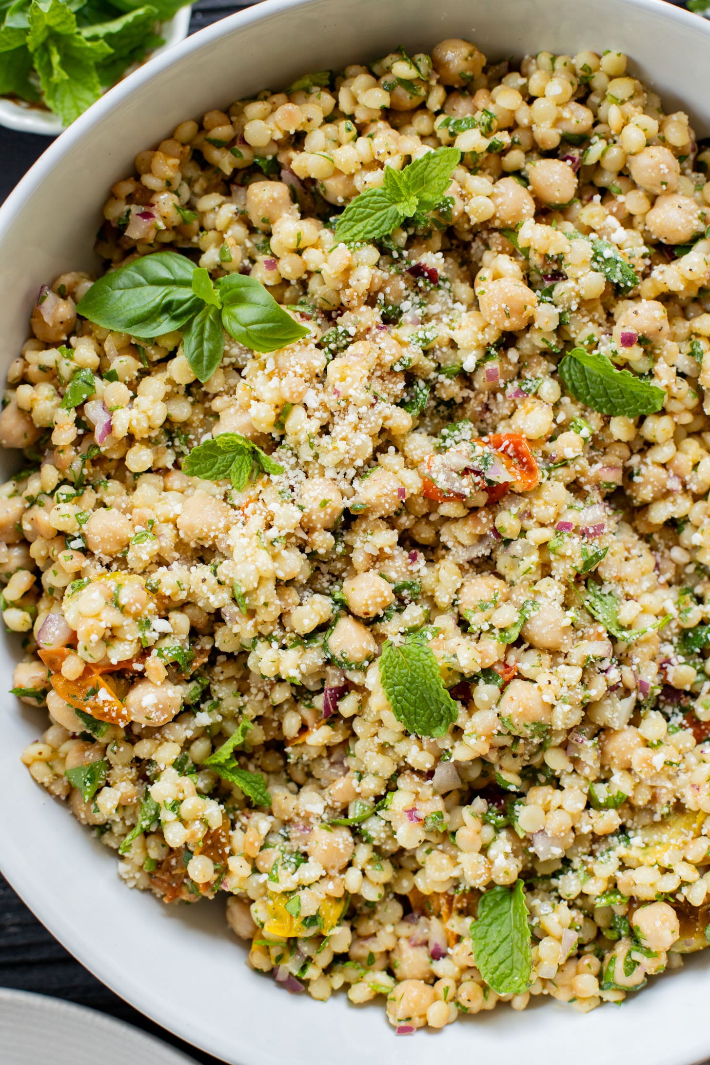This Lemon Herb Couscous Salad is packed with fresh herbs, chickpeas, vegan parmesan and a simple & delicious dressing | ThisSavoryVegan.com