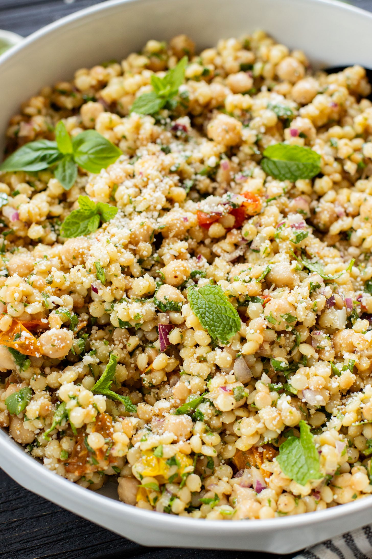 This Lemon Herb Couscous Salad is packed with fresh herbs, chickpeas, vegan parmesan and a simple & delicious dressing | ThisSavoryVegan.com