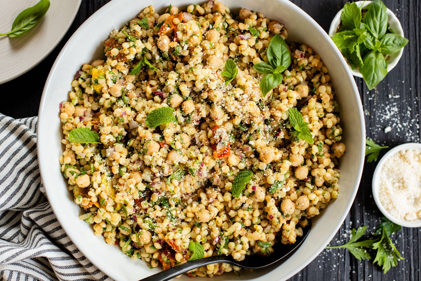 This Lemon Herb Couscous Salad is packed with fresh herbs, chickpeas, vegan parmesan and a simple & delicious dressing | ThisSavoryVegan.com