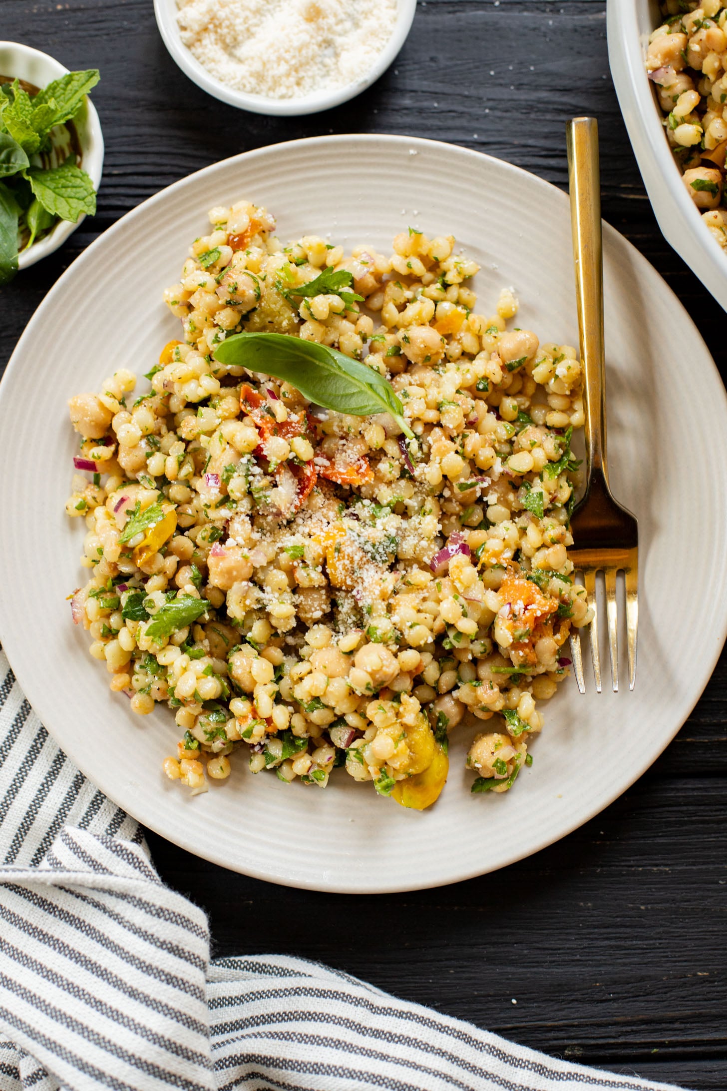 This Lemon Herb Couscous Salad is packed with fresh herbs, chickpeas, vegan parmesan and a simple & delicious dressing | ThisSavoryVegan.com