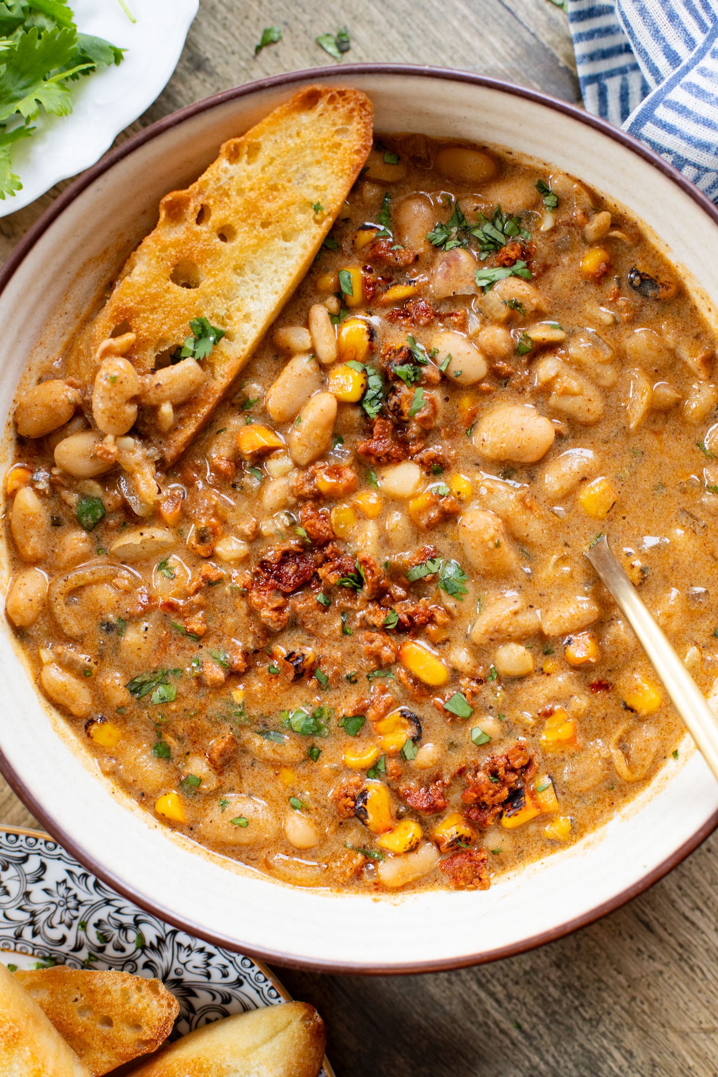 This Creamy White Beans & Soy Chorizo recipe is a cozy one-pot dinner. The beans are simmered in a creamy broth & topped with soy chorizo & corn | ThisSavoryVegan.com