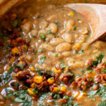 This Creamy White Beans & Soy Chorizo recipe is a cozy one-pot dinner. The beans are simmered in a creamy broth & topped with soy chorizo & corn | ThisSavoryVegan.com