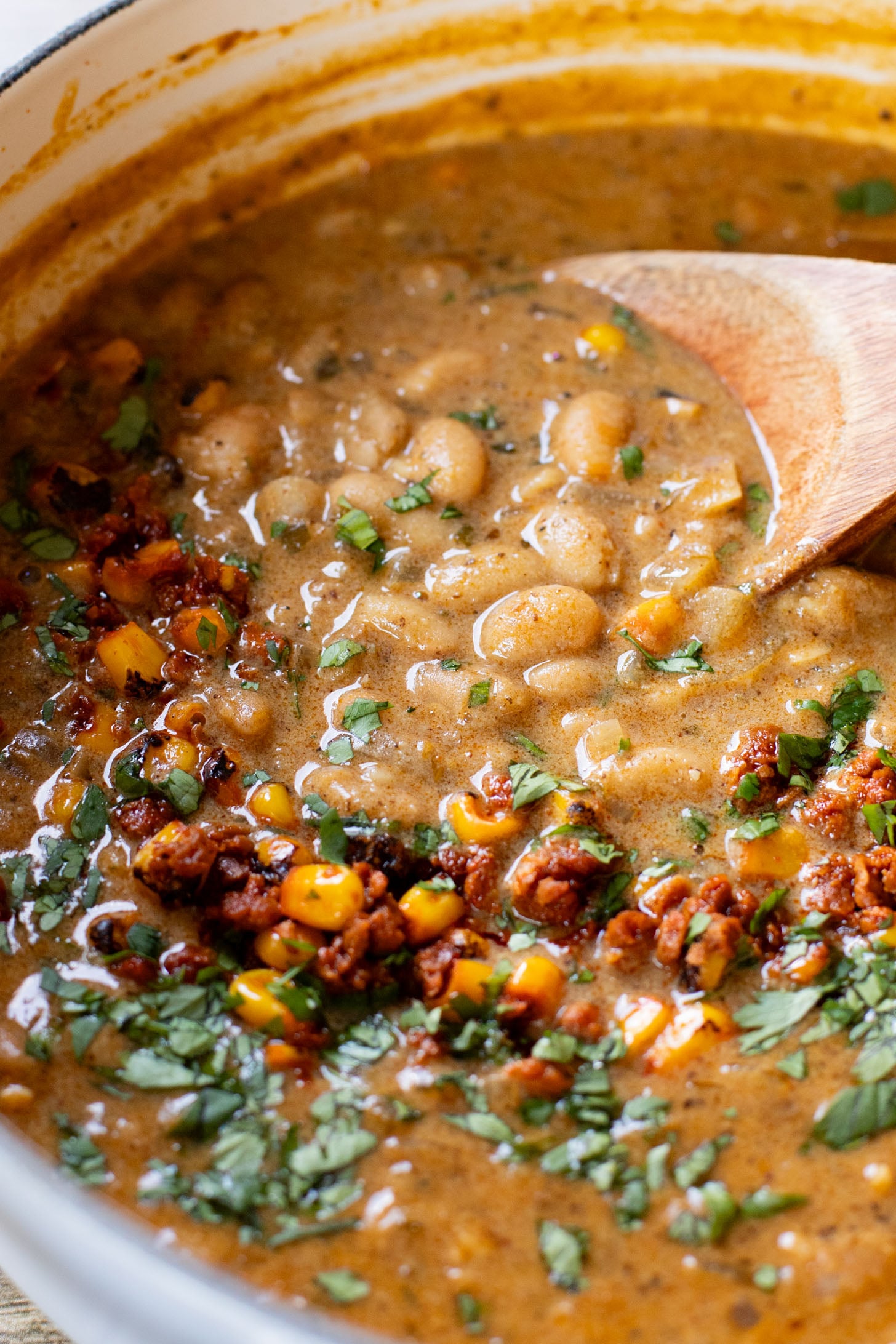 This Creamy White Beans & Soy Chorizo recipe is a cozy one-pot dinner. The beans are simmered in a creamy broth & topped with soy chorizo & corn | ThisSavoryVegan.com