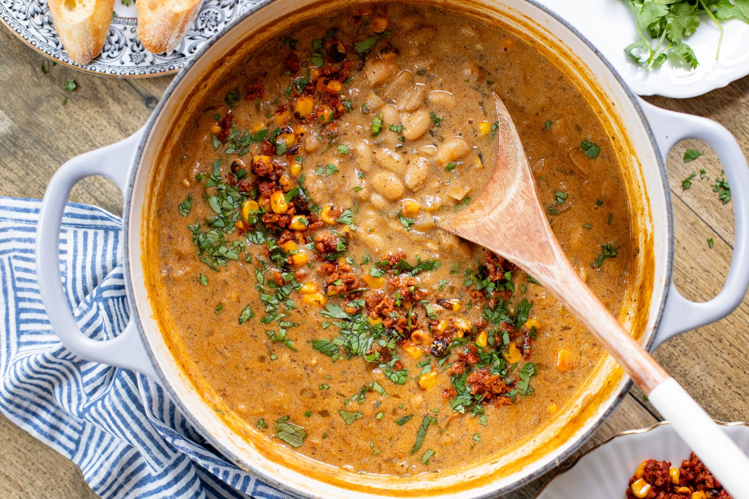 This Creamy White Beans & Soy Chorizo recipe is a cozy one-pot dinner. The beans are simmered in a creamy broth & topped with soy chorizo & corn | ThisSavoryVegan.com
