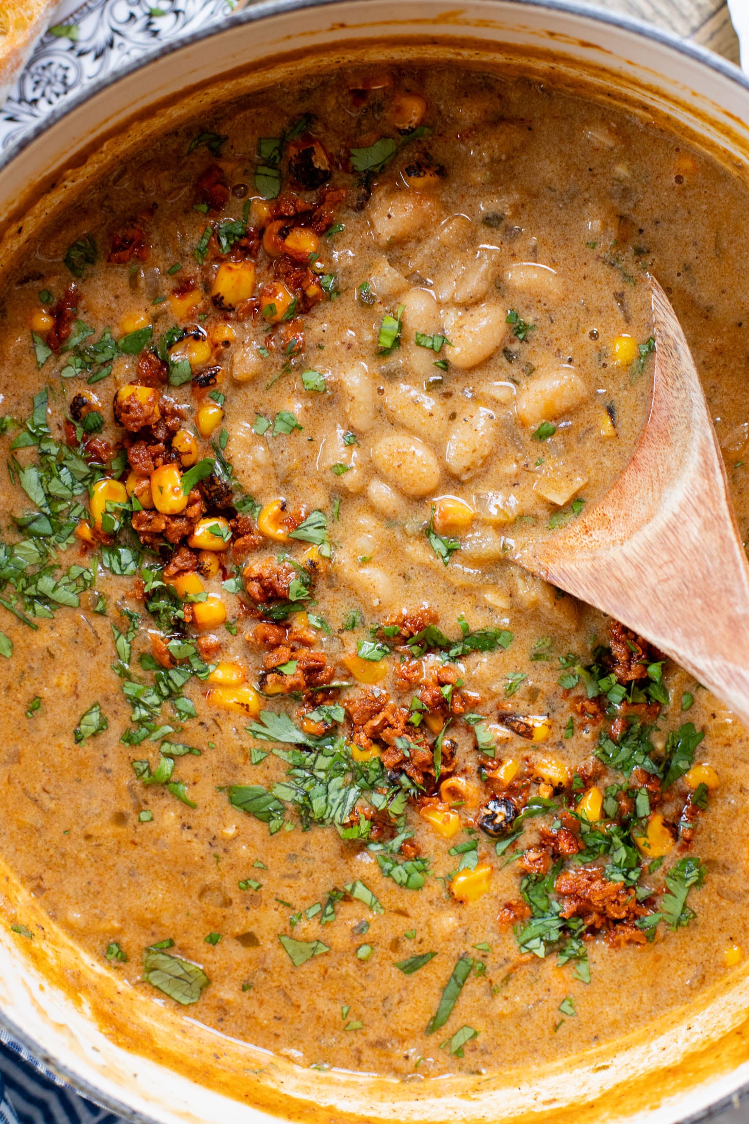 This Creamy White Beans & Soy Chorizo recipe is a cozy one-pot dinner. The beans are simmered in a creamy broth & topped with soy chorizo & corn | ThisSavoryVegan.com