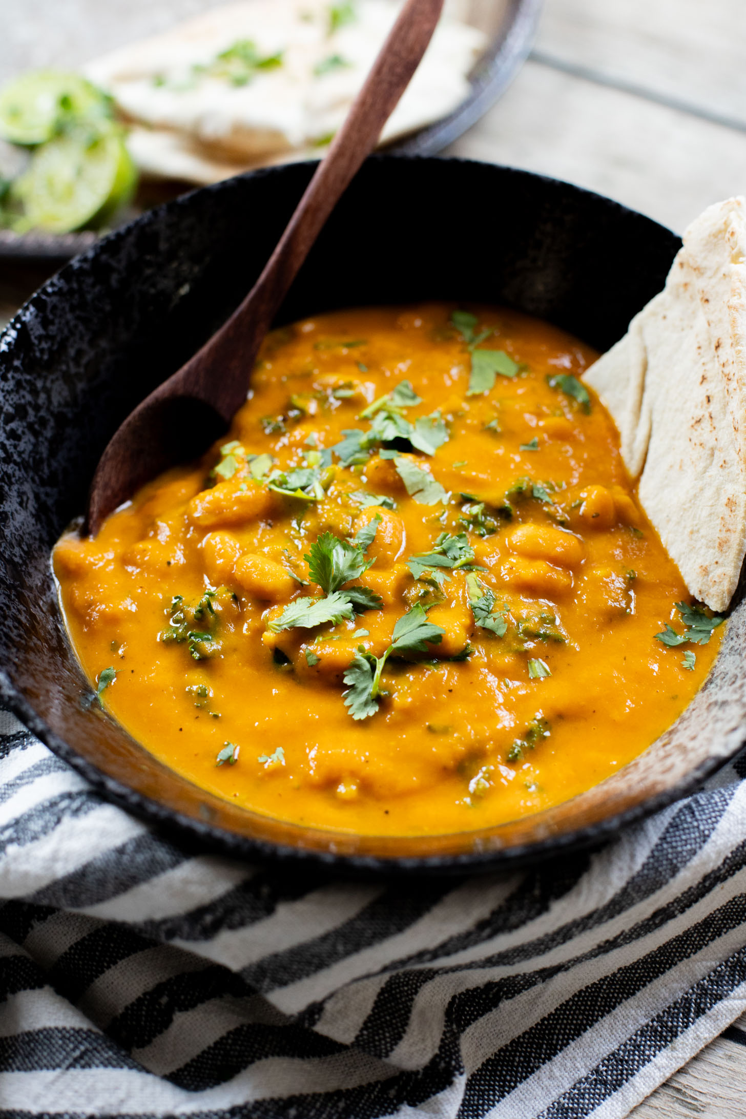 This Curried White Beans & Kale recipe is cozy and veggie packed! Beans are simmered in a coconut & squash sauce to make a delicious vegan curry | ThisSavoryVegan.com