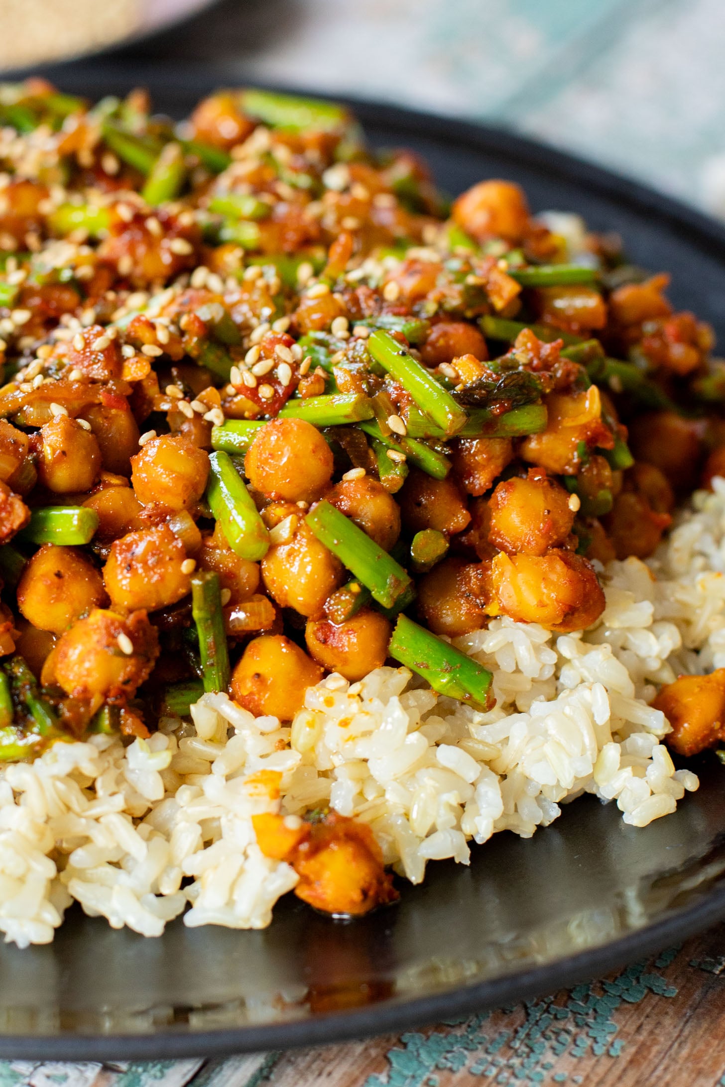 This Harissa Chickpeas & Asparagus recipe is the best skillet dinner. Made with simple vegan ingredients and served over rice for a tasty meal | ThisSavoryVegan.com