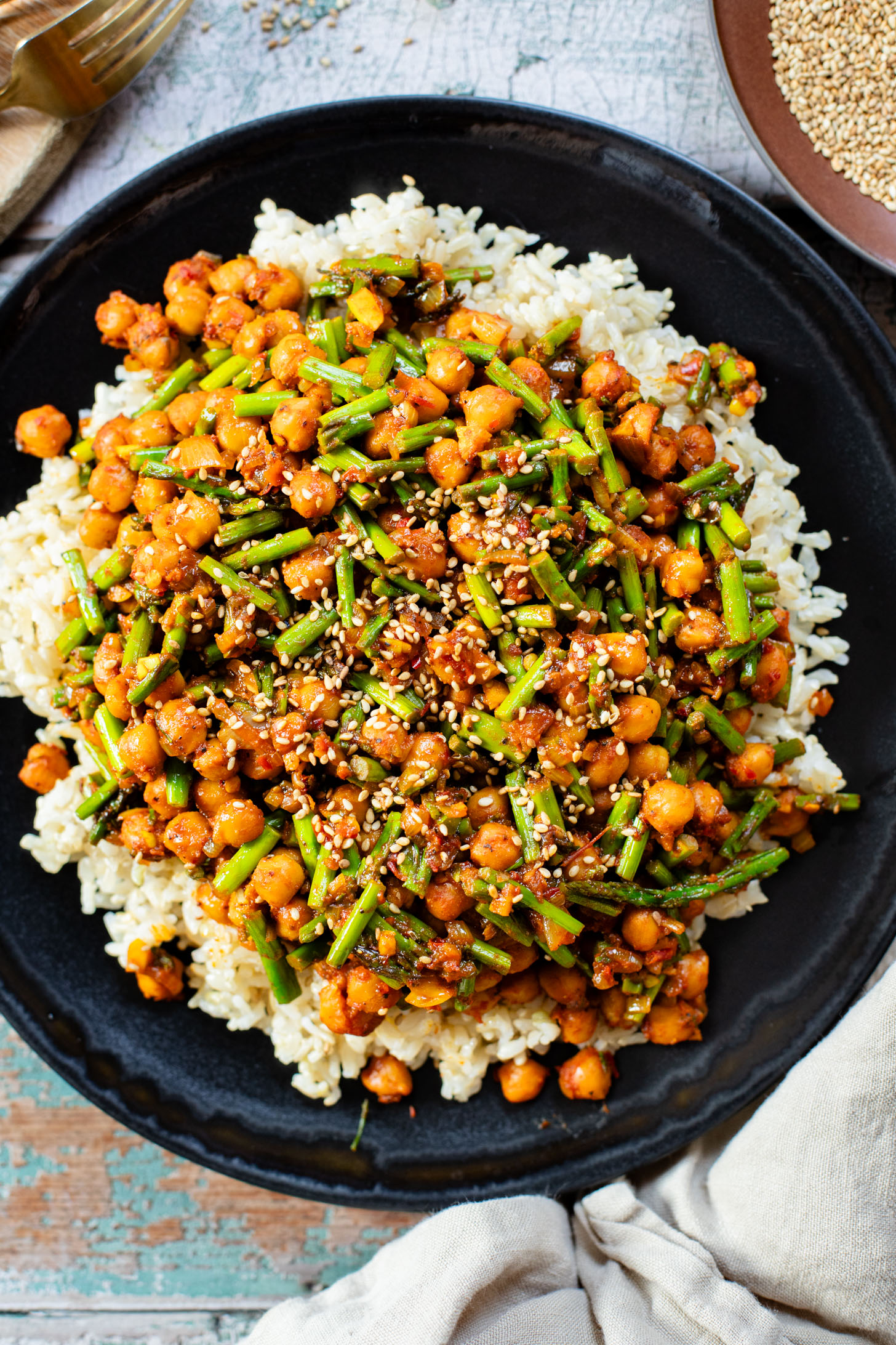This Harissa Chickpeas & Asparagus recipe is the best skillet dinner. Made with simple vegan ingredients and served over rice for a tasty meal | ThisSavoryVegan.com