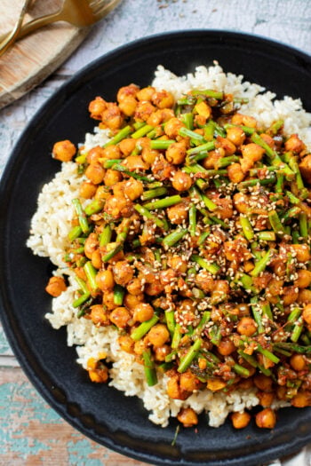 This Harissa Chickpeas & Asparagus recipe is the best skillet dinner. Made with simple vegan ingredients and served over rice for a tasty meal | ThisSavoryVegan.com