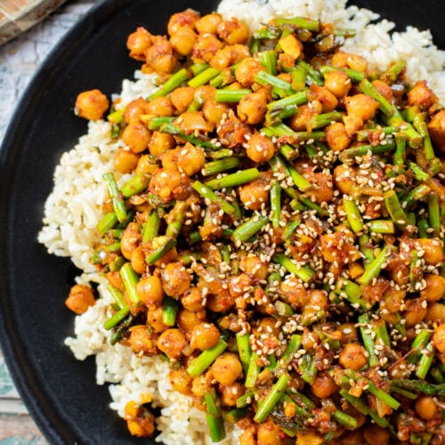 This Harissa Chickpeas & Asparagus recipe is the best skillet dinner. Made with simple vegan ingredients and served over rice for a tasty meal | ThisSavoryVegan.com