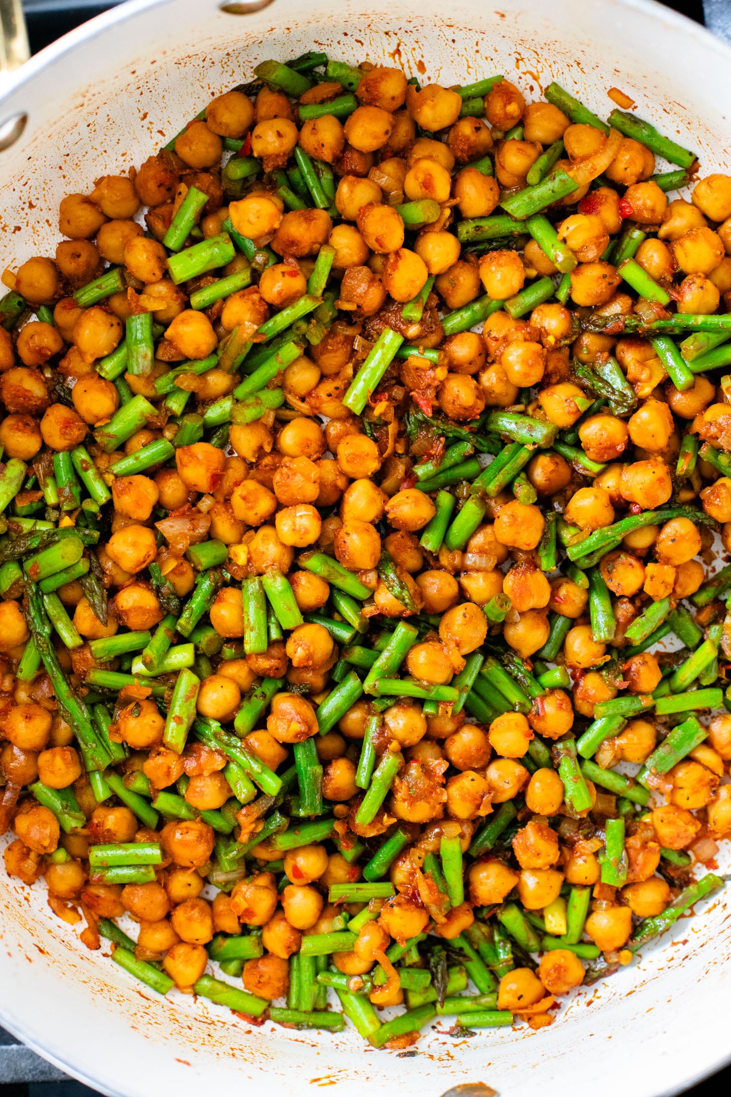 This Harissa Chickpeas & Asparagus recipe is the best skillet dinner. Made with simple vegan ingredients and served over rice for a tasty meal | ThisSavoryVegan.com