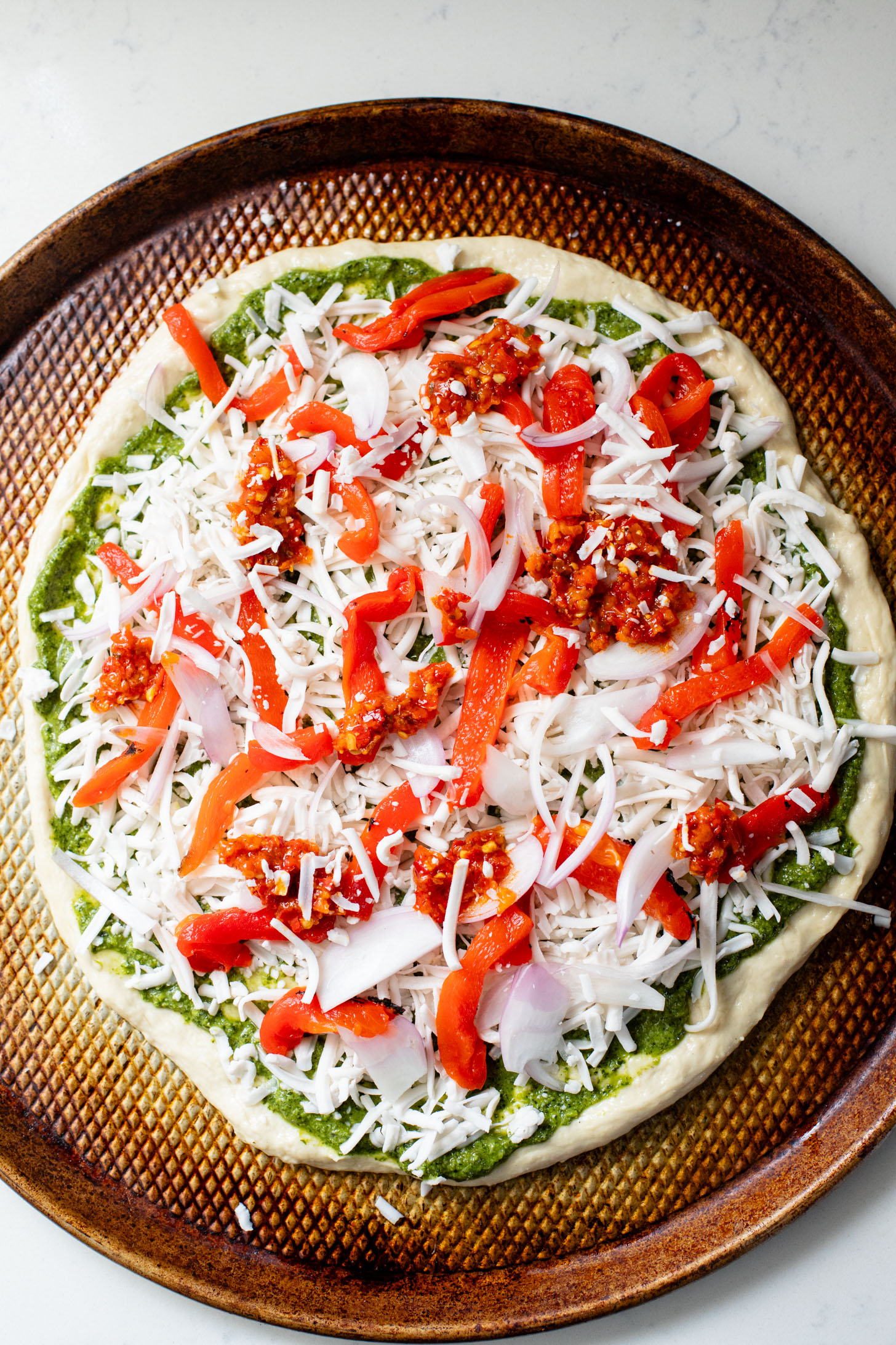 This Roasted Red Pepper Pesto Pizza is a delicious and easy vegan pizza recipe! Fresh, bright flavors on a crispy pizza crust | ThisSavoryVegan.com