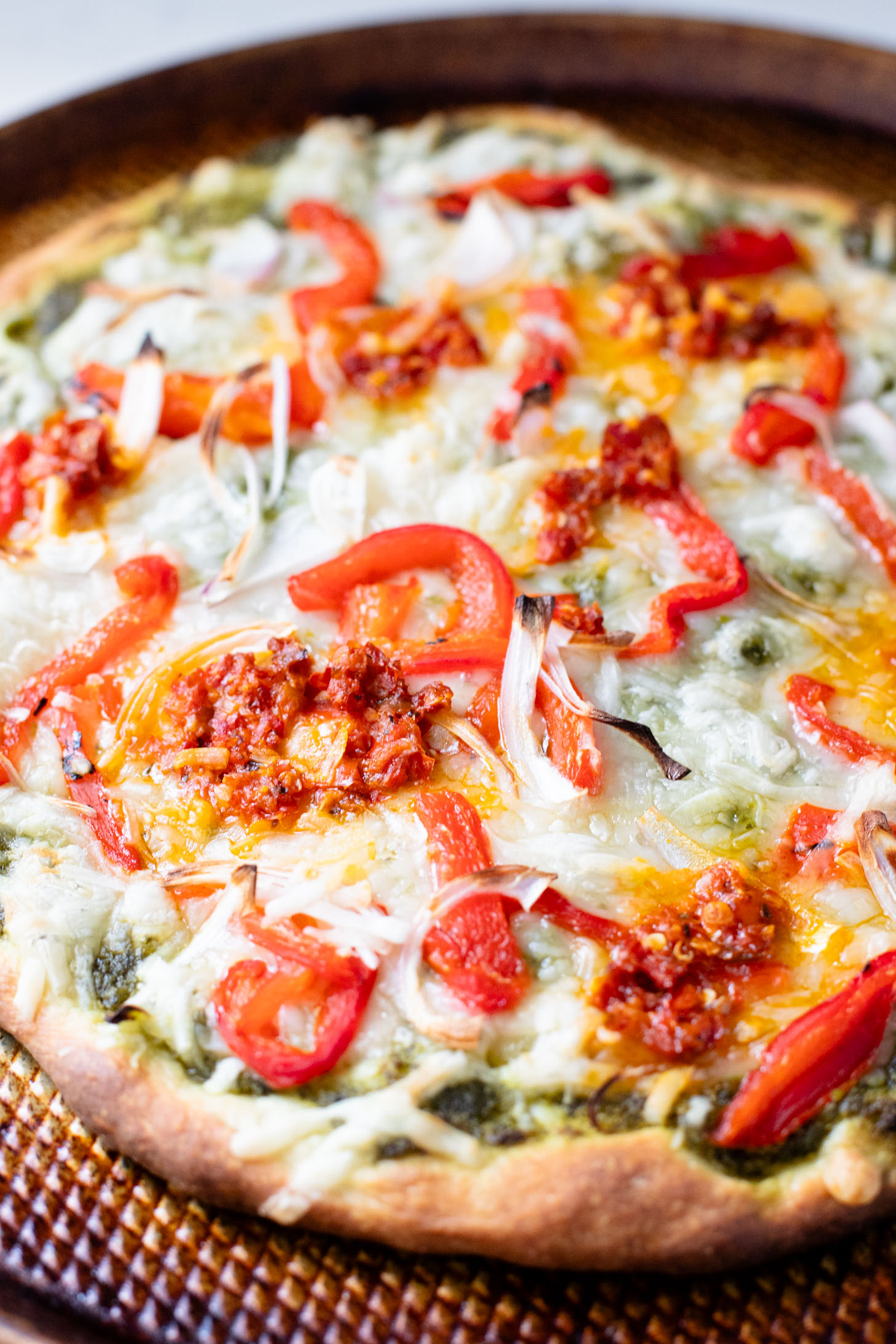 This Roasted Red Pepper Pesto Pizza is a delicious and easy vegan pizza recipe! Fresh, bright flavors on a crispy pizza crust | ThisSavoryVegan.com