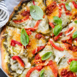 This Roasted Red Pepper Pesto Pizza is a delicious and easy vegan pizza recipe! Fresh, bright flavors on a crispy pizza crust | ThisSavoryVegan.com
