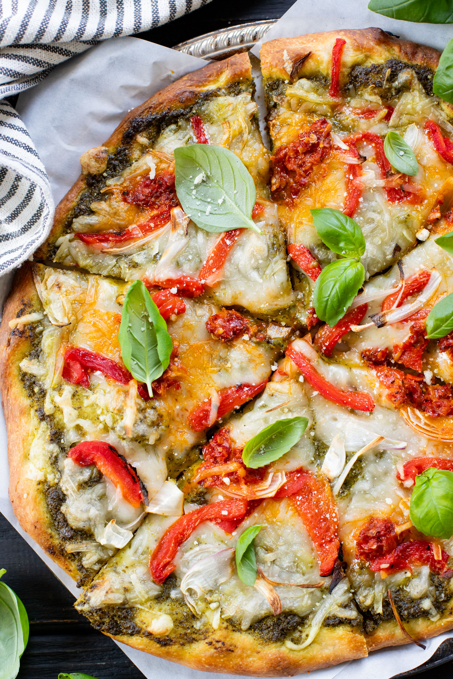 This Roasted Red Pepper Pesto Pizza is a delicious and easy vegan pizza recipe! Fresh, bright flavors on a crispy pizza crust | ThisSavoryVegan.com