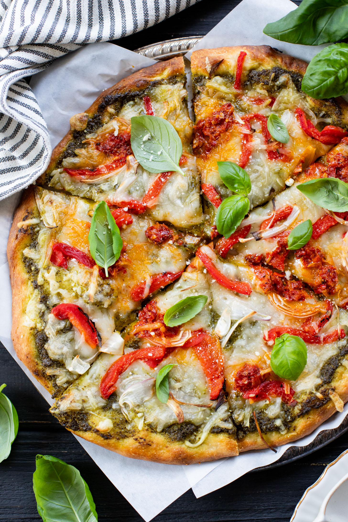 This Roasted Red Pepper Pesto Pizza is a delicious and easy vegan pizza recipe! Fresh, bright flavors on a crispy pizza crust | ThisSavoryVegan.com