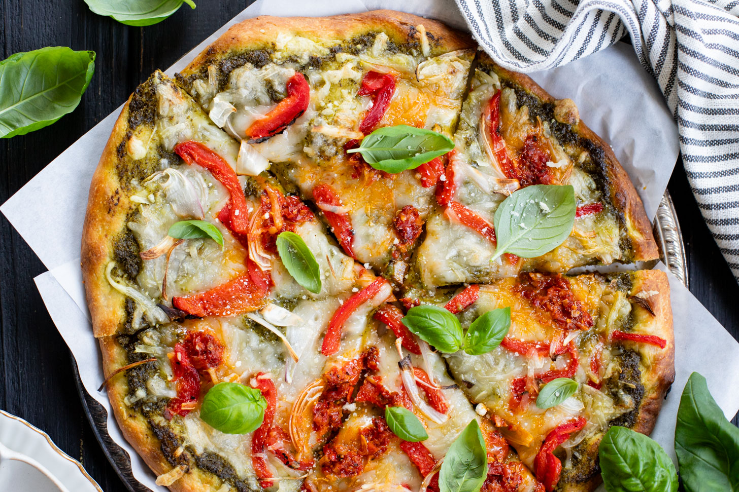 This Roasted Red Pepper Pesto Pizza is a delicious and easy vegan pizza recipe! Fresh, bright flavors on a crispy pizza crust | ThisSavoryVegan.com