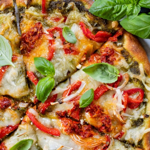 This Roasted Red Pepper Pesto Pizza is a delicious and easy vegan pizza recipe! Fresh, bright flavors on a crispy pizza crust | ThisSavoryVegan.com