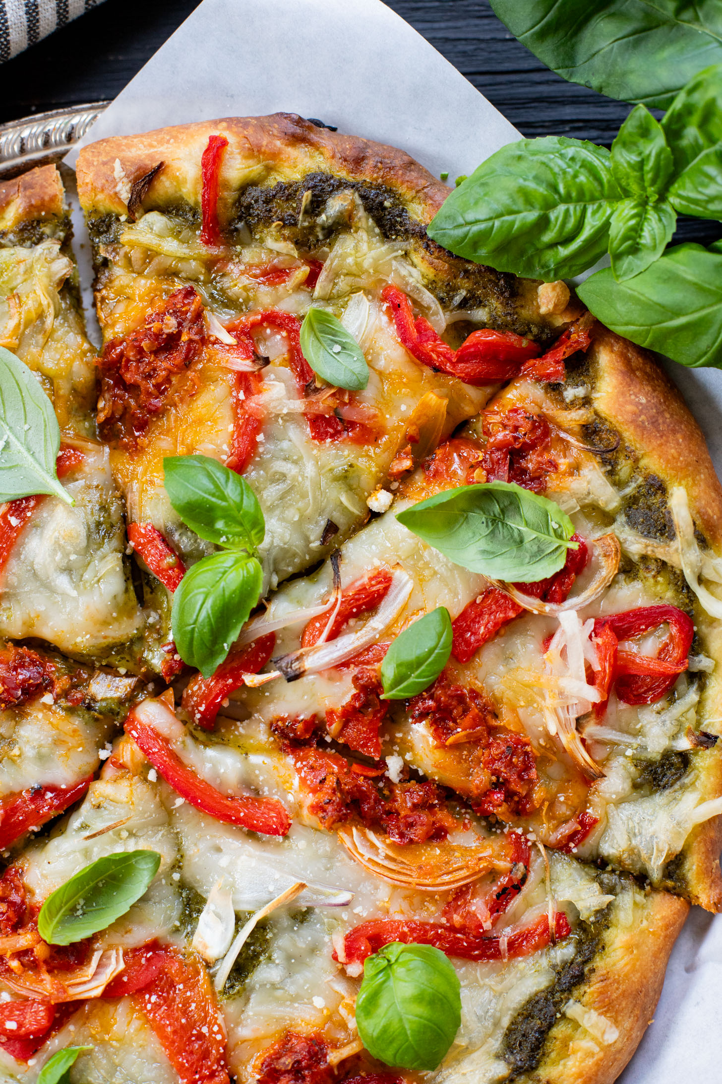 This Roasted Red Pepper Pesto Pizza is a delicious and easy vegan pizza recipe! Fresh, bright flavors on a crispy pizza crust | ThisSavoryVegan.com