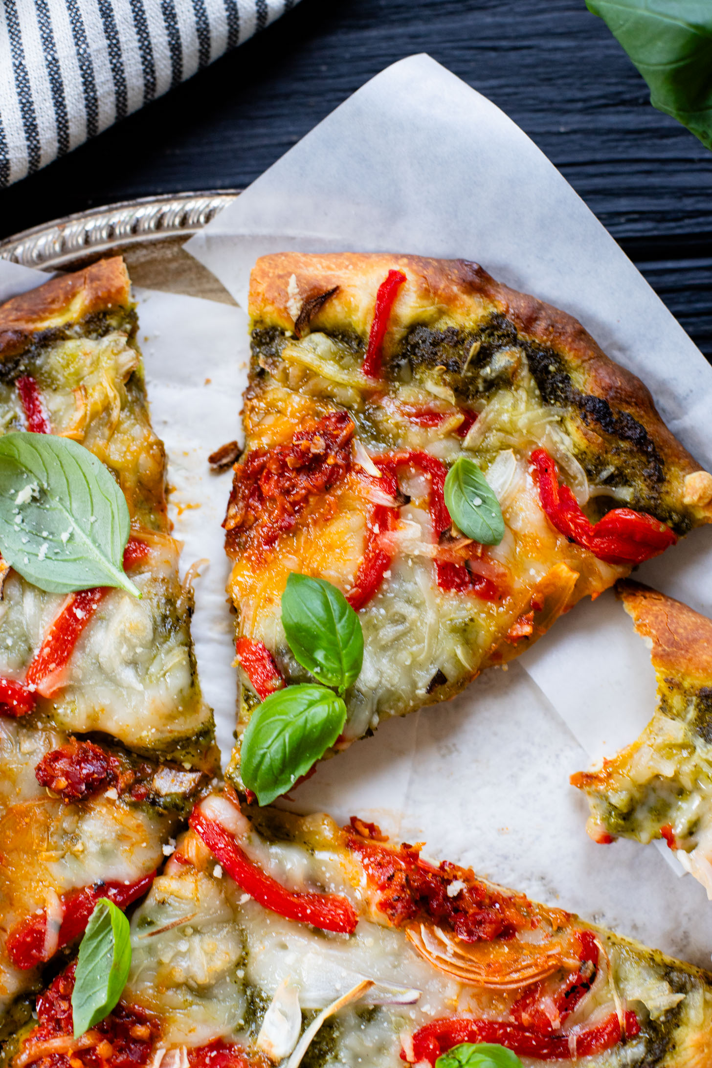 This Roasted Red Pepper Pesto Pizza is a delicious and easy vegan pizza recipe! Fresh, bright flavors on a crispy pizza crust | ThisSavoryVegan.com