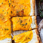 This Cheesy Butternut Squash Tart is the perfect holiday appetizer! Puff pastry is layered with non-dairy cheese and thinly sliced butternut squash | ThisSavoryVegan.com