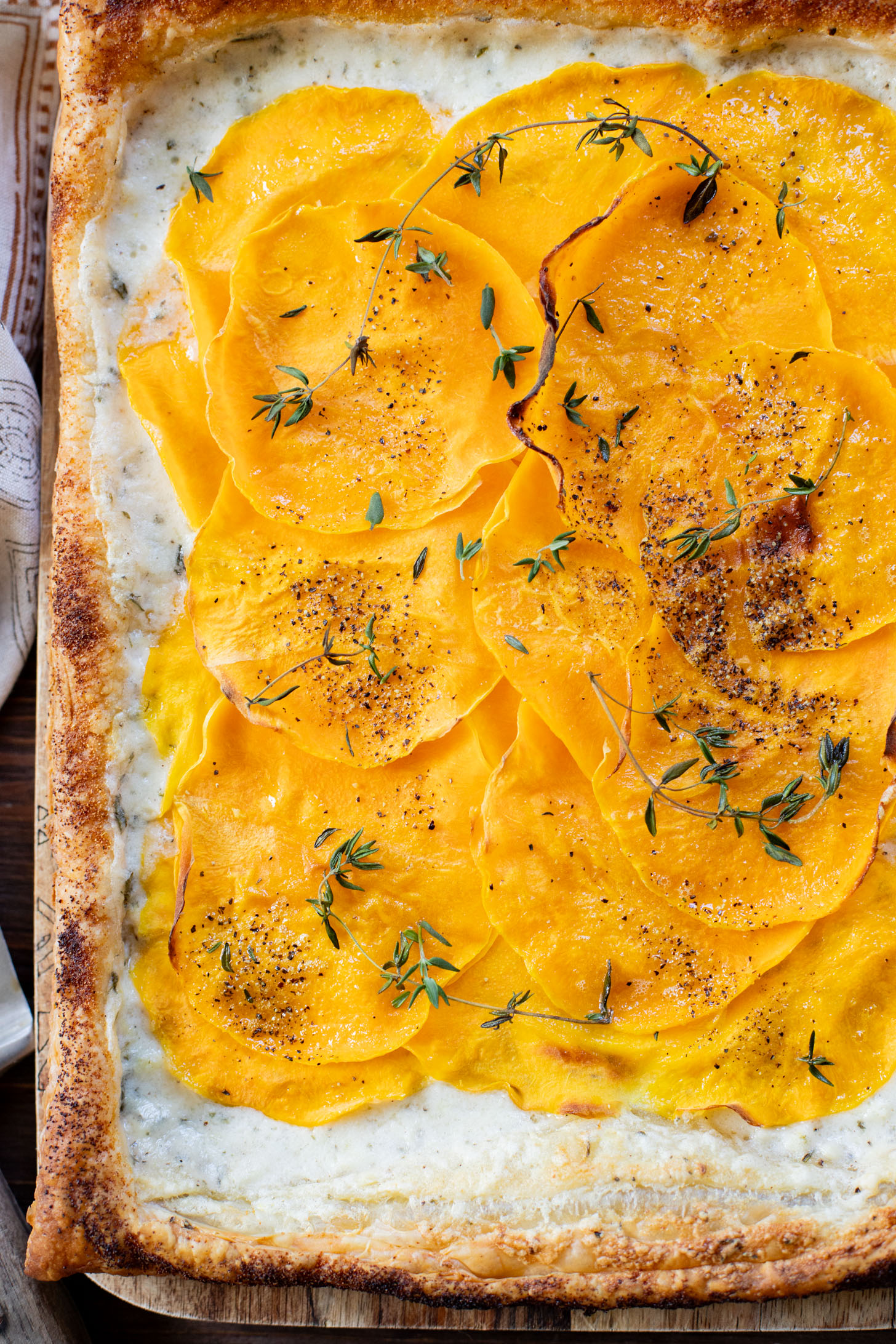 This Cheesy Butternut Squash Tart is the perfect holiday appetizer! Puff pastry is layered with non-dairy cheese and thinly sliced butternut squash | ThisSavoryVegan.com