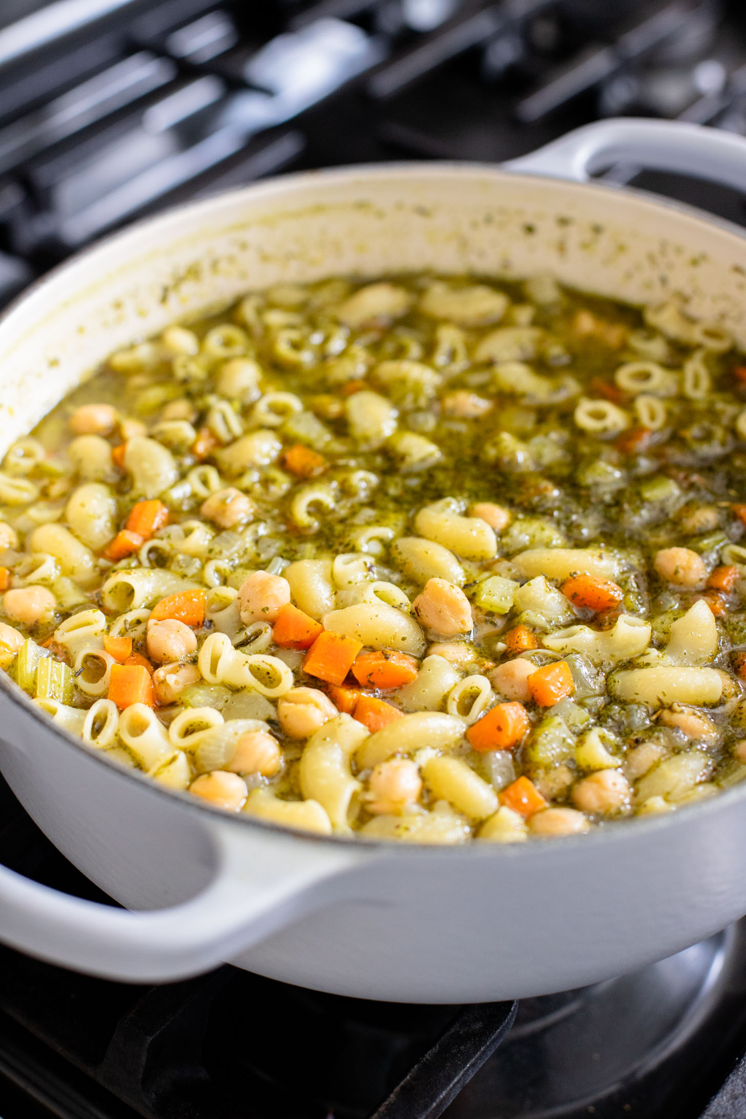 This Chickpea Pesto Macaroni Soup is a quick and tasty vegan soup recipe. A tasty broth, tender macaroni, chickpeas & veggies | ThisSavoryVegan.com