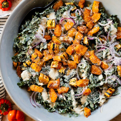 This Fall Harvest Salad is filled with roasted delicata squash, kale & red onion tossed in a creamy tahini dressing. Serve as a main or a side | ThisSavoryVegan.com