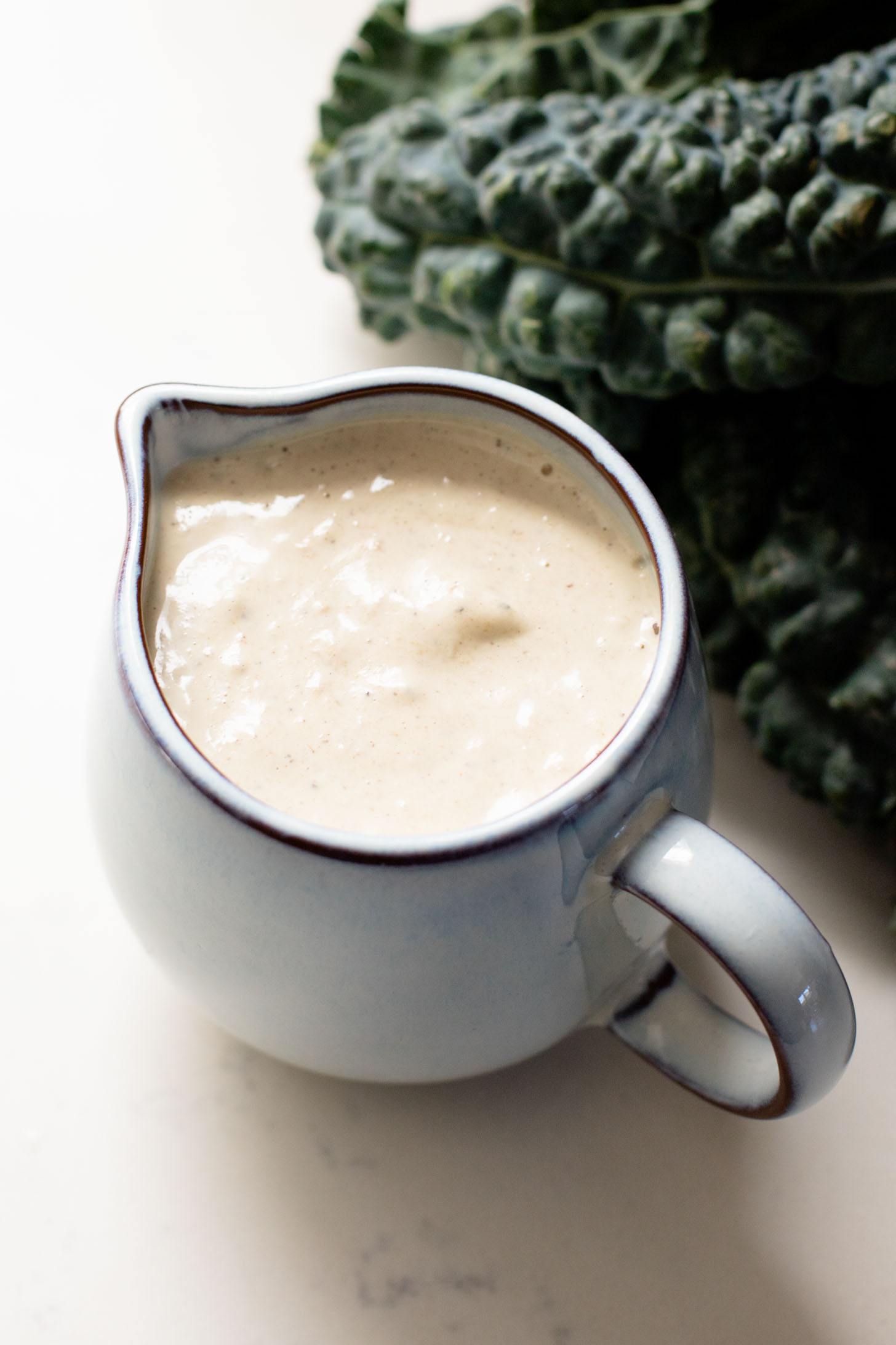 This Fall Harvest Salad is filled with roasted delicata squash, kale & red onion tossed in a creamy tahini dressing. Serve as a main or a side | ThisSavoryVegan.com