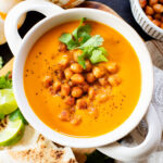 Creamy and comforting, this Thai Curry Pumpkin Soup is a dairy-free fall soup that everyone will love. Topped with crispy chickpeas | ThisSavoryVegan.com
