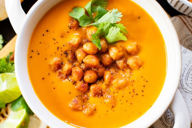 Creamy and comforting, this Thai Curry Pumpkin Soup is a dairy-free fall soup that everyone will love. Topped with crispy chickpeas | ThisSavoryVegan.com