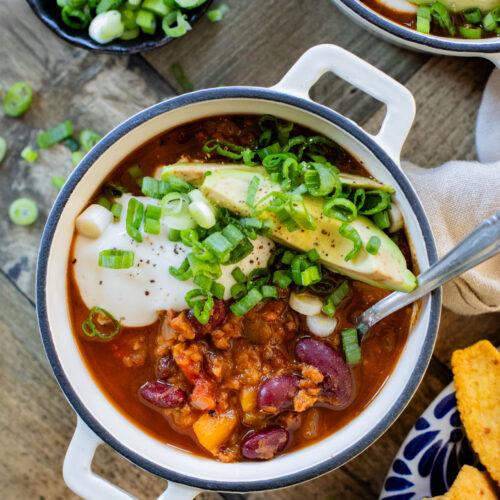 This Slow Cooker Butternut Squash Chili is a fall dream! The mix of kidney beans & butternut squash chunks makes for a hearty & healthy vegan chili | ThisSavoryVegan.com