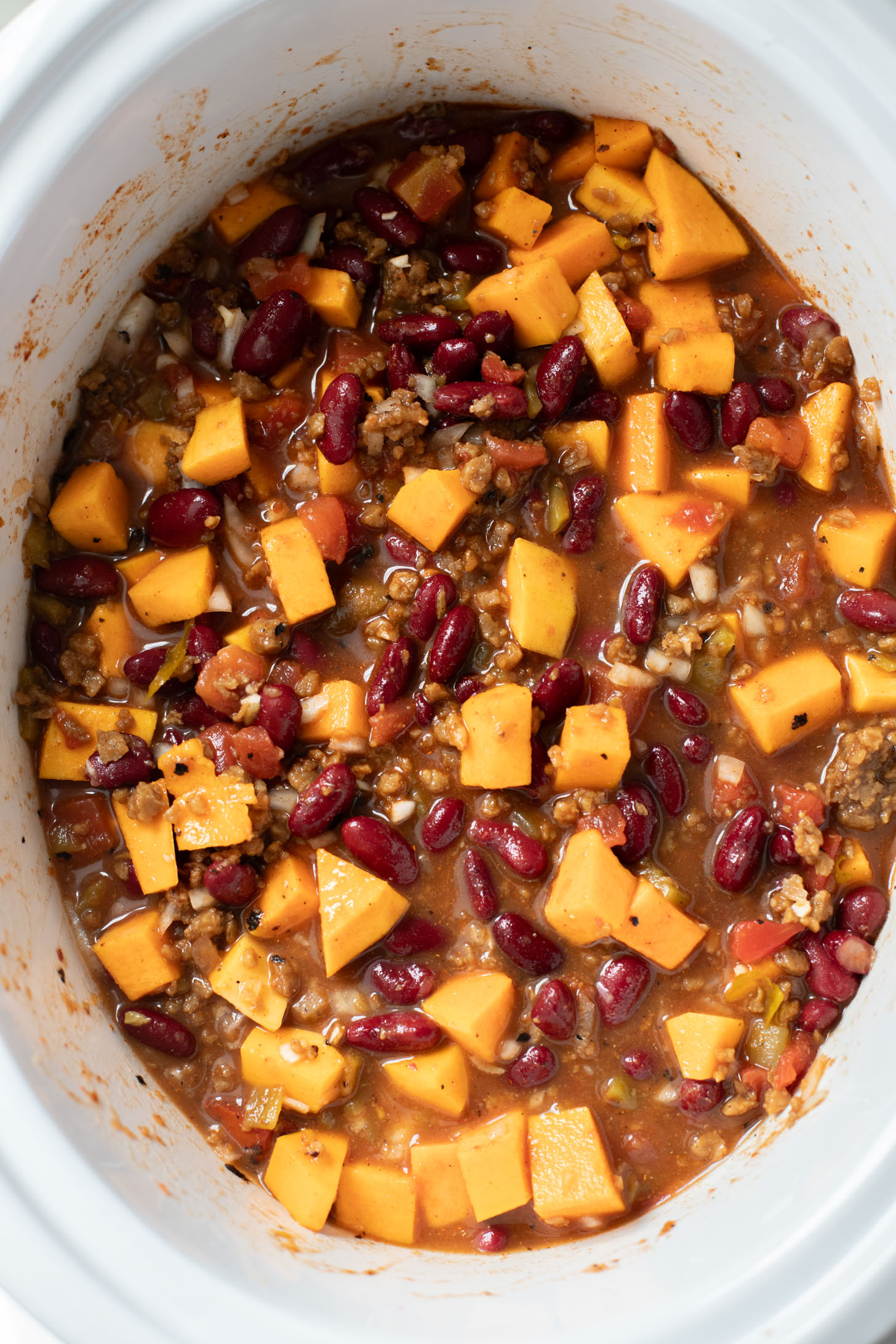 This Slow Cooker Butternut Squash Chili is a fall dream! The mix of kidney beans & butternut squash chunks makes for a hearty & healthy vegan chili | ThisSavoryVegan.com