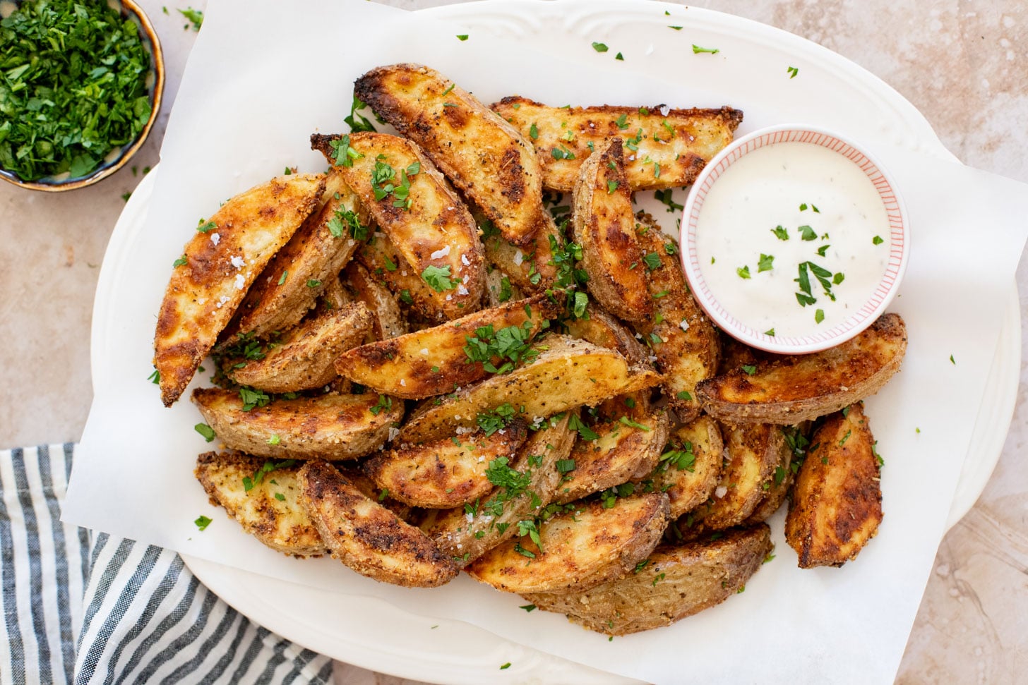 These Vegan Parmesan Crusted Potato Wedges are the most satisfying way to eat potatoes. Perfectly crispy and garlicky | ThisSavoryVegan.com