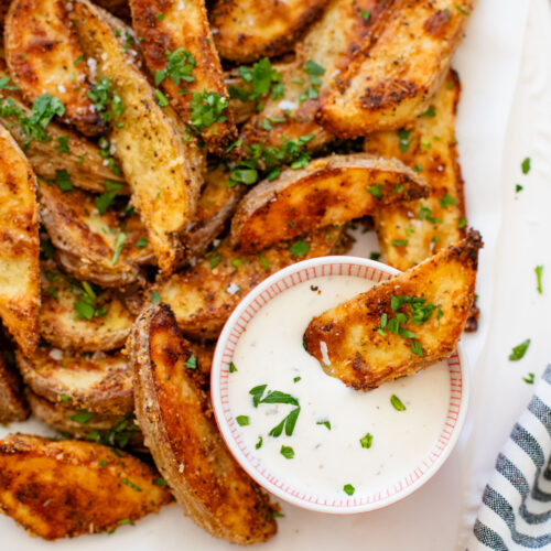 These Vegan Parmesan Crusted Potato Wedges are the most satisfying way to eat potatoes. Perfectly crispy and garlicky | ThisSavoryVegan.com