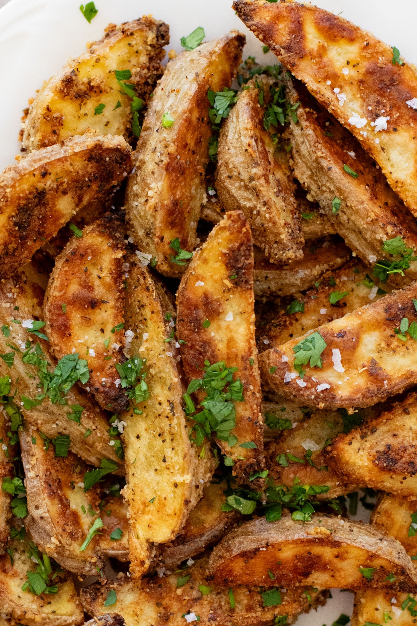 These Vegan Parmesan Crusted Potato Wedges are the most satisfying way to eat potatoes. Perfectly crispy and garlicky | ThisSavoryVegan.com
